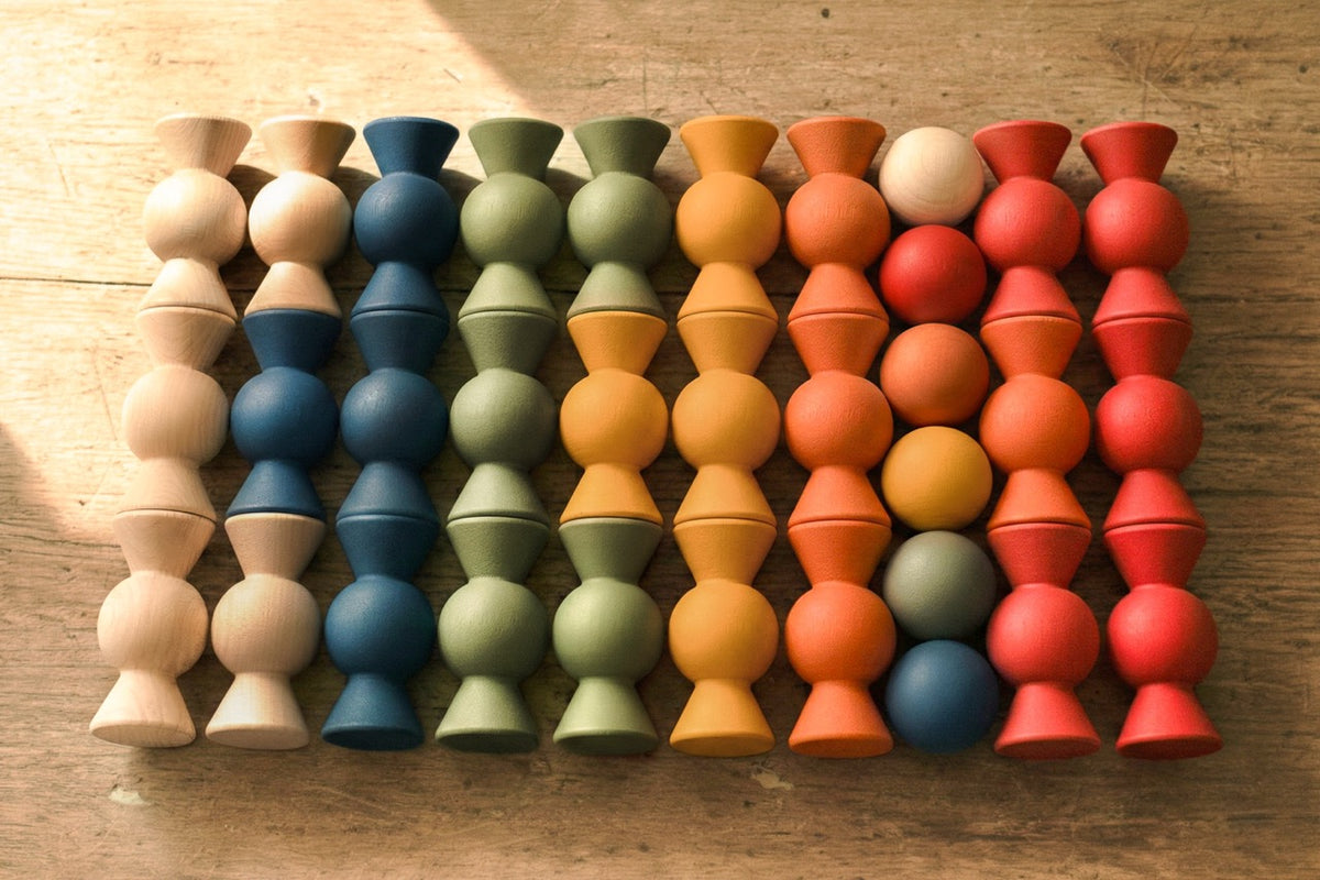 Overhead view of Chill Pepper Sweets Forest Fruits wooden sweets and gumballs arranged in rows by colour.